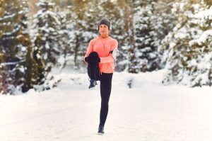 mujer calentando en el exterior con nieve