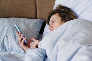 mujer en la cama con móvil