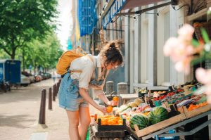 mujer seleccionando fruta y verdura en una tienda a pie de calle