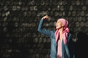 mujer con cáncer con pañuelo rosa y actitud positiva