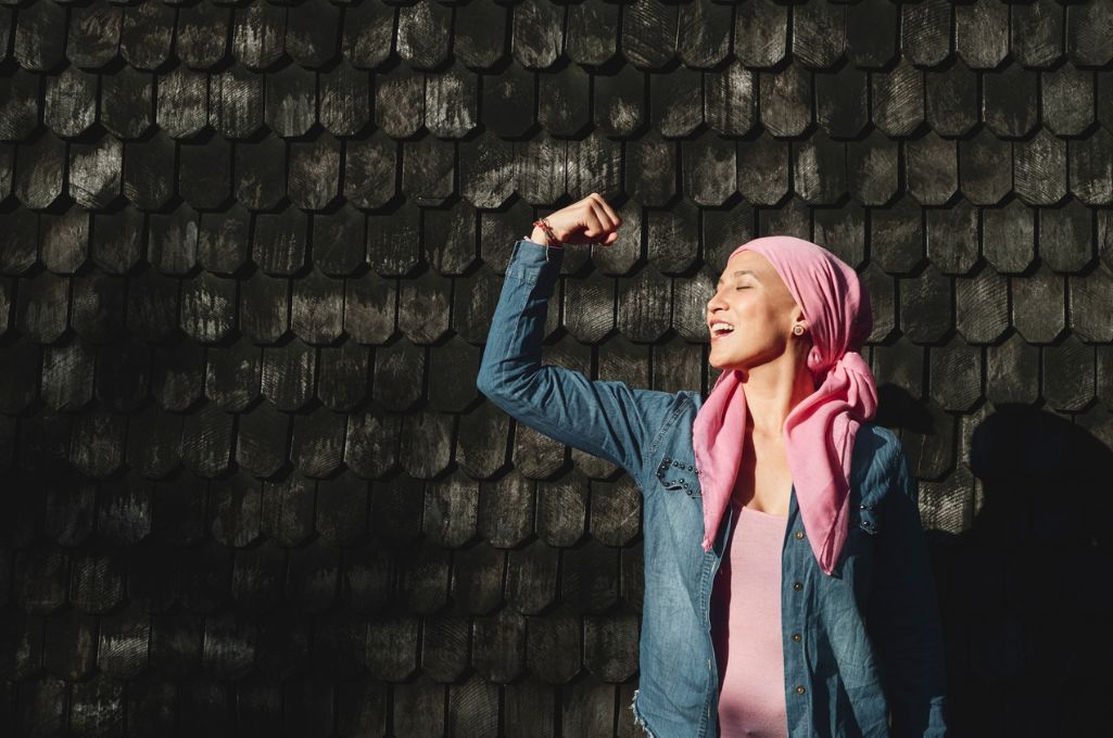 mujer con cáncer con pañuelo rosa y actitud positiva
